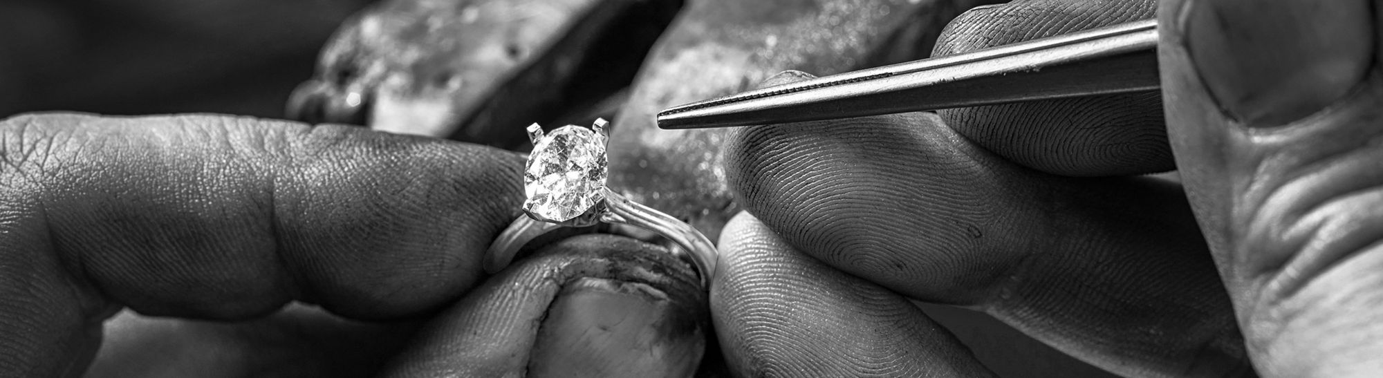 Desktop image of a jeweler setting an oval center diamond in an engagement ring